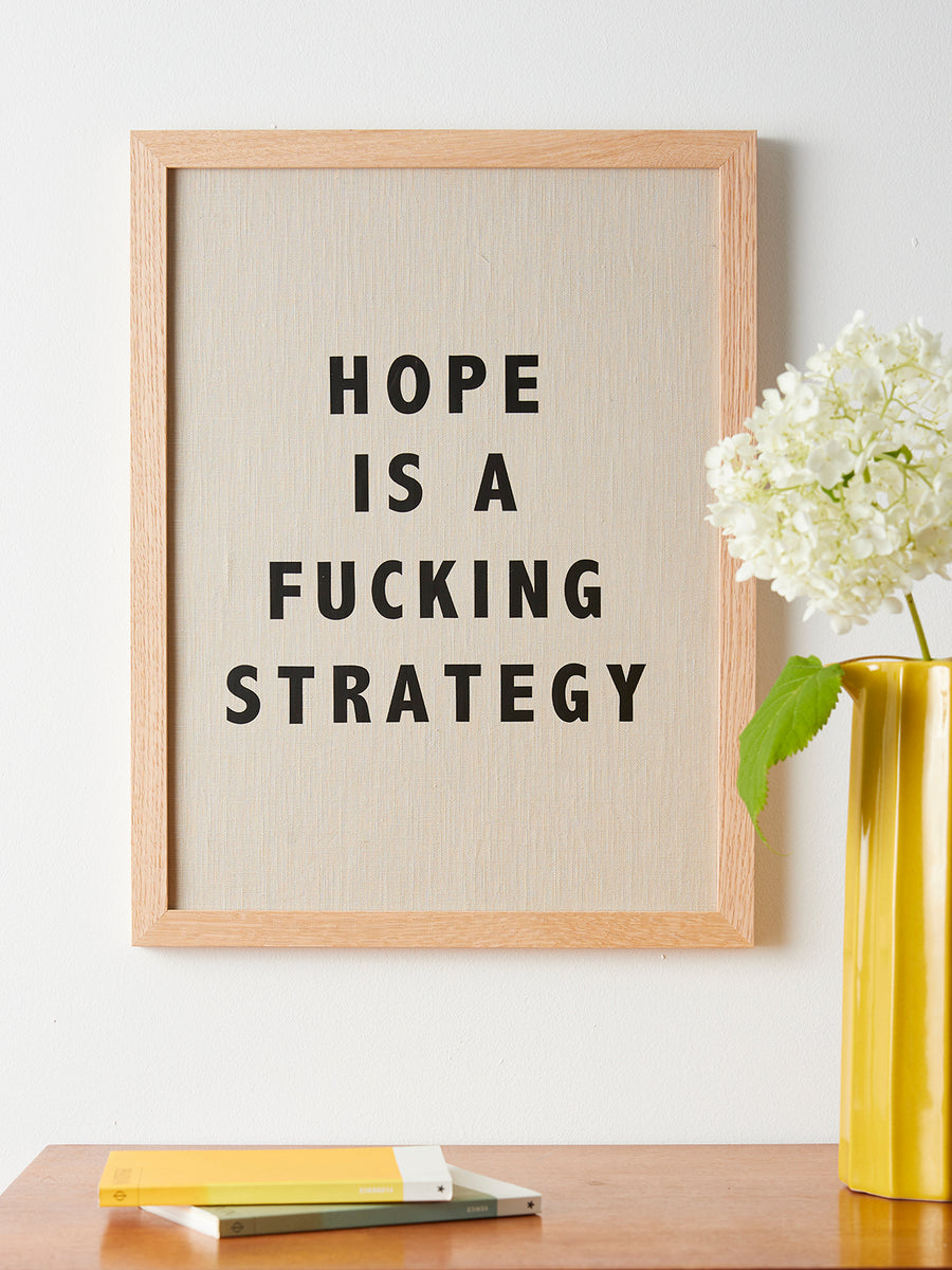 Catherine Colebrook framed linen quote picture, 'Hope is a Fucking Strategy' in natural linen with black text, in an oak frame