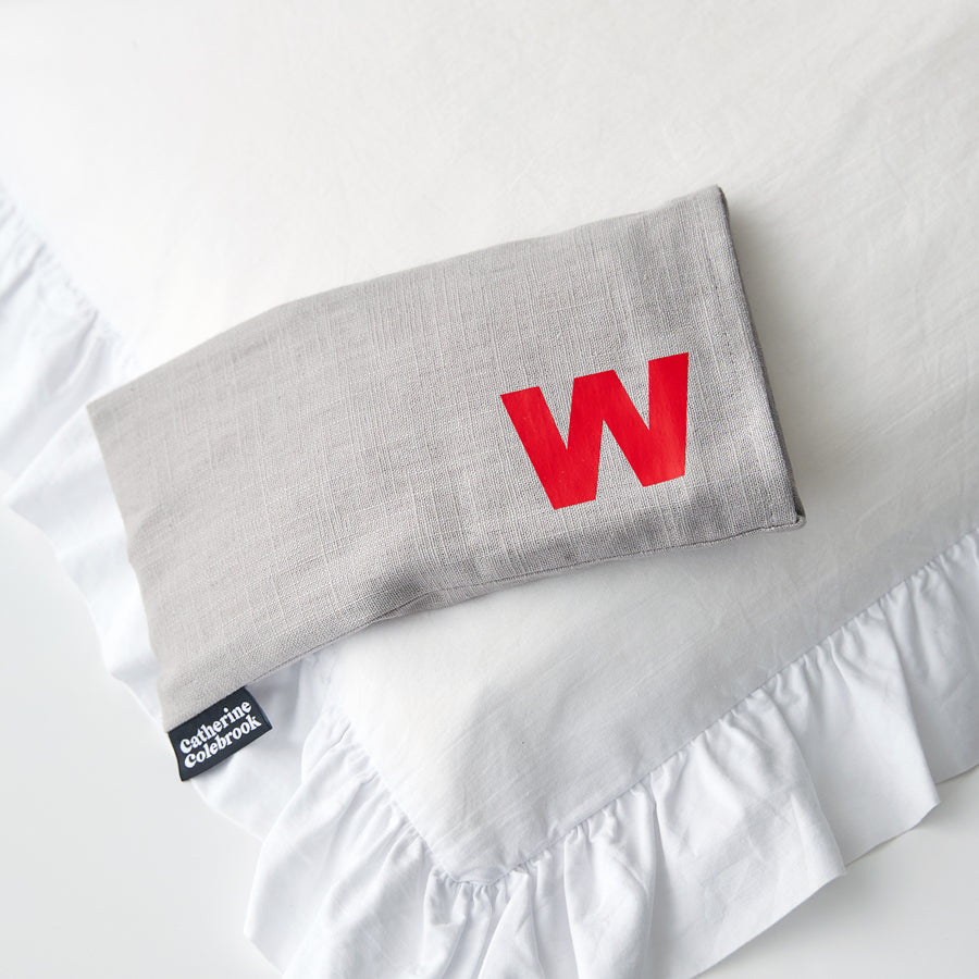Catherine Colebrook grey linen eye pillow with red initial on the bottom right with optional lavender