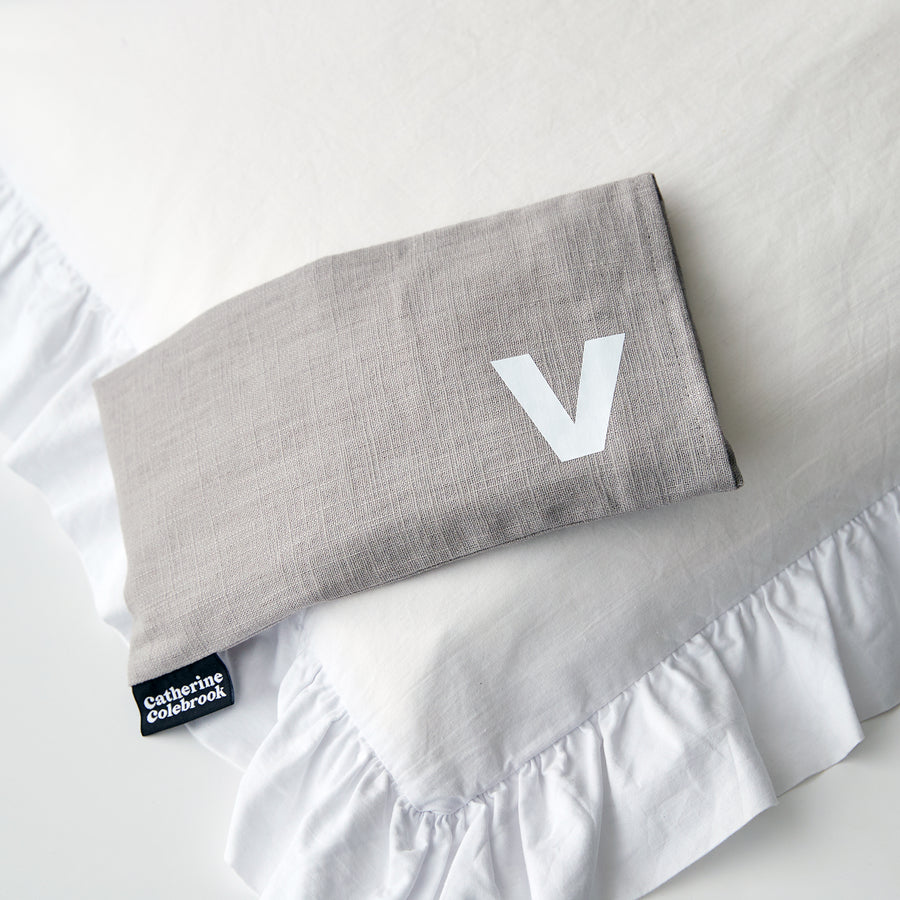 Catherine Colebrook grey linen eye pillow with white initial on the bottom right with optional lavender