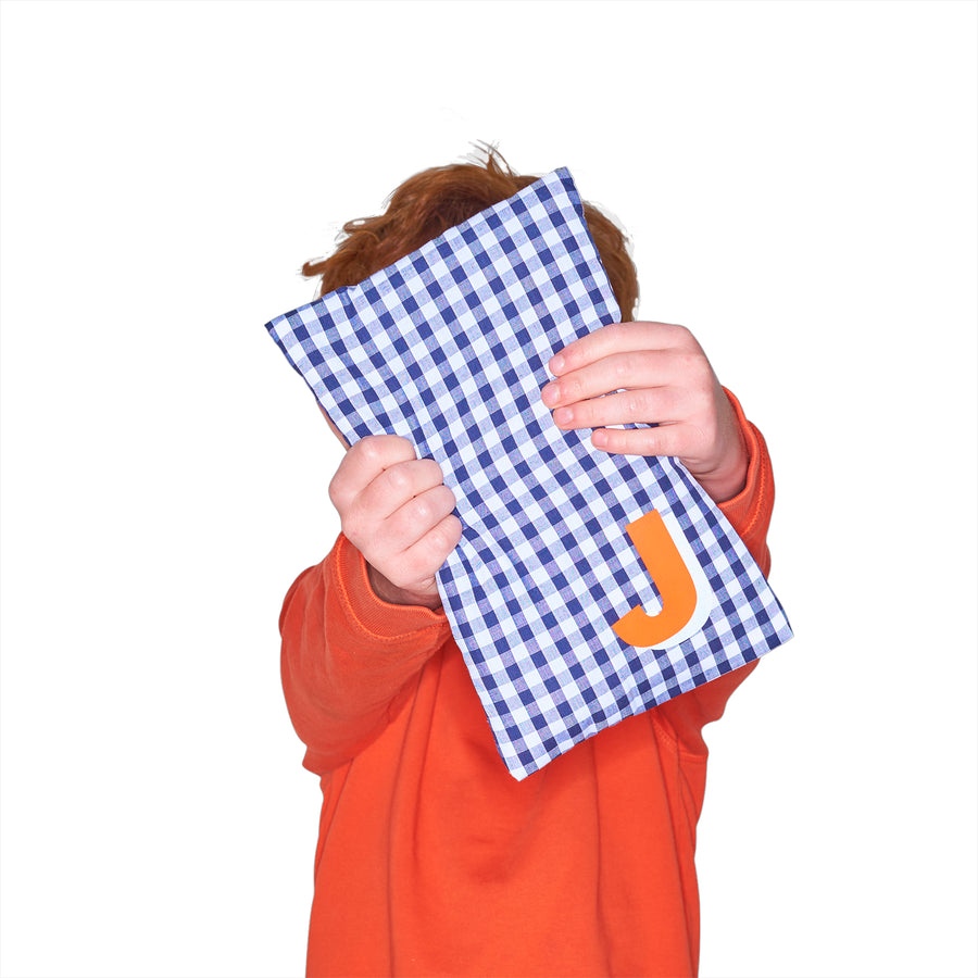 Catherine Colebrook cute navy gingham hot water bottle with ‘3D’ style initial in bottom right corner in orange with white highlights being held by young boy