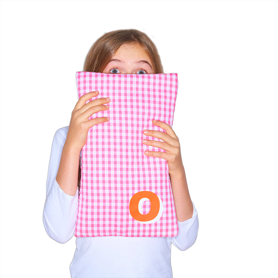 Catherine Colebrook pink gingham hot water bottle with ‘3D’ style initial in bottom right corner in orange with white highlights being held by young girl