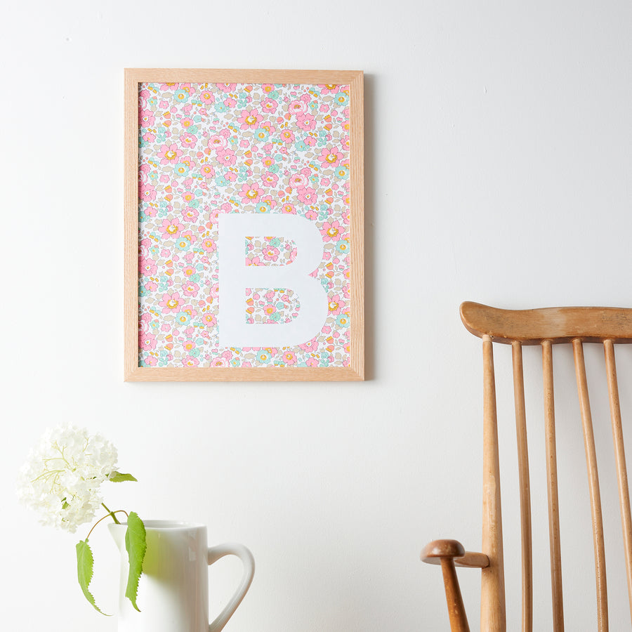 Catherine Colebrook framed Liberty initial picture, in Betsy Pink fabric with white letter, in an oak frame
