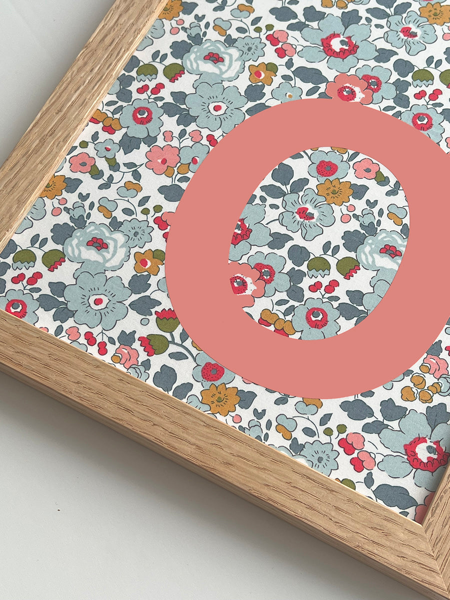 Catherine Colebrook framed Liberty initial picture, in Betsy Blue fabric with salmon pink letter, in an oak frame