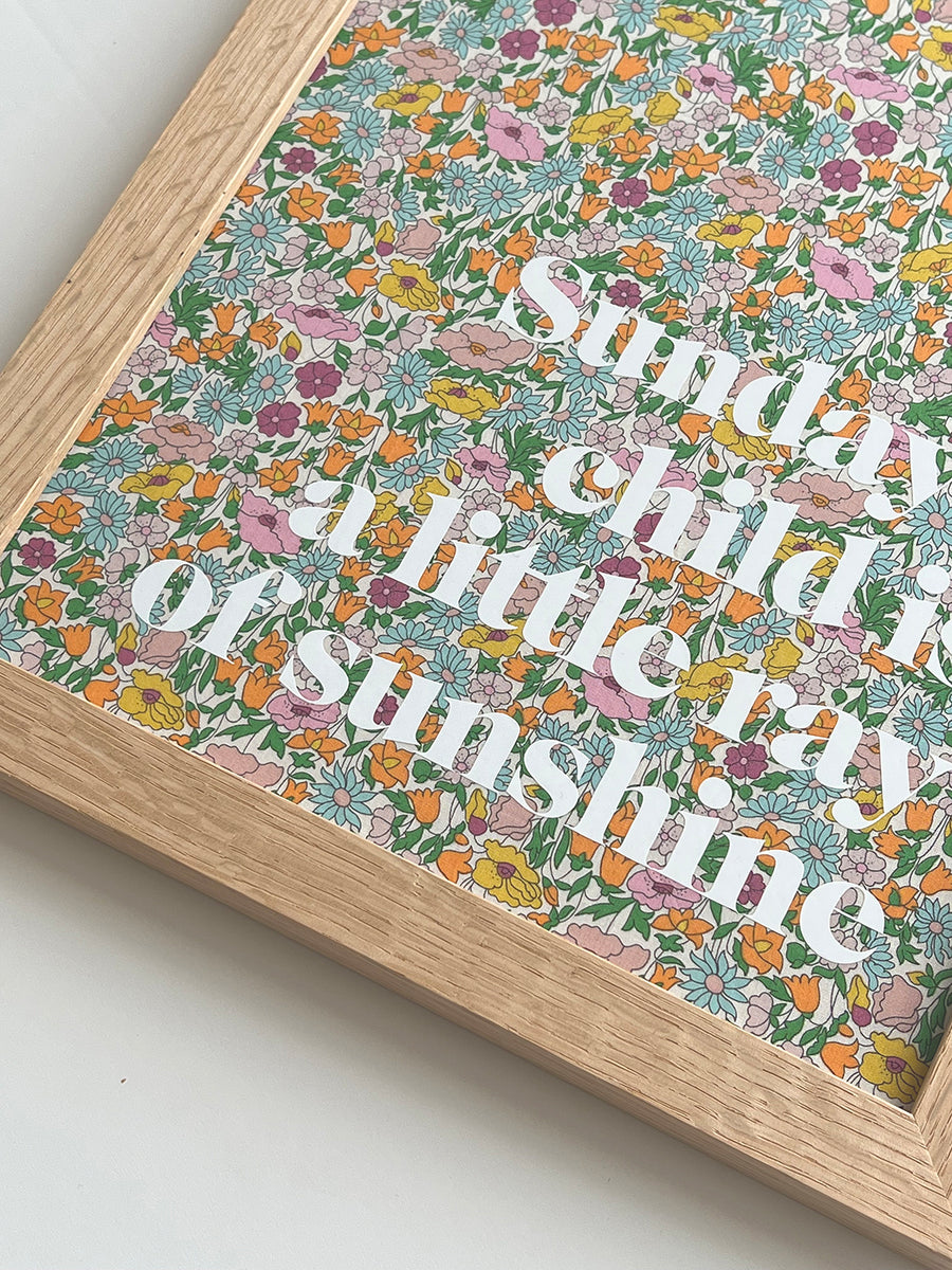 Catherine Colebrook framed Liberty ‘Monday’s Child’ nursery rhyme quote picture, in Poppy Forest Liberty Tana Lawn with white text, in an oak frame - close up