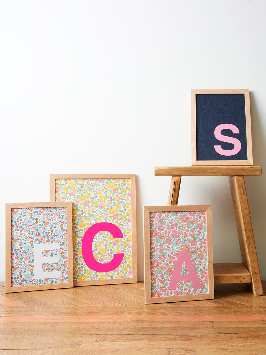 Catherine Colebrook framed initial pictures in denim and Liberty fabrics with different initial colour way options, in oak frames