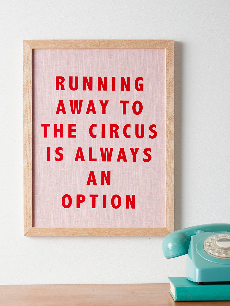 Catherine Colebrook framed linen quote picture, ‘Running Away to the Circus' in pink linen with red text, in an oak frame
