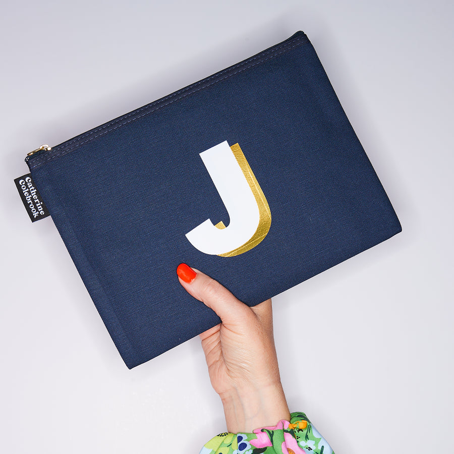 HAND HOLDING LARGE COTTON NAVY PURSE WITH A WHITE LETTER J ON IT