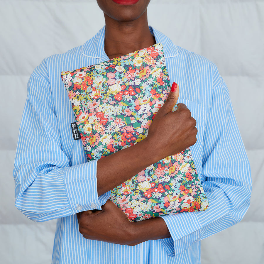 woman hugging green/pink Liberty print hot water bottle