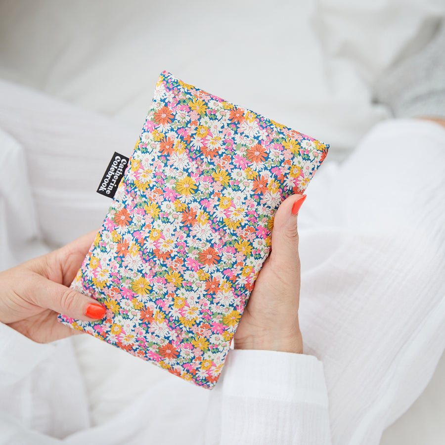 Hand holding cute hot water bottle in Pink Yellow Liberty print.