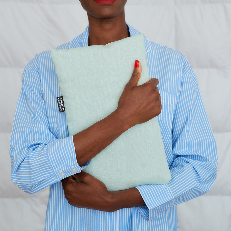 woman hugging plain mint linen hot water bottle