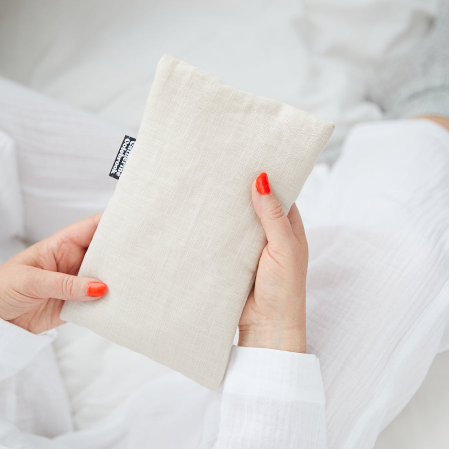 Hand holding cute hot water bottle in Natural Linen.