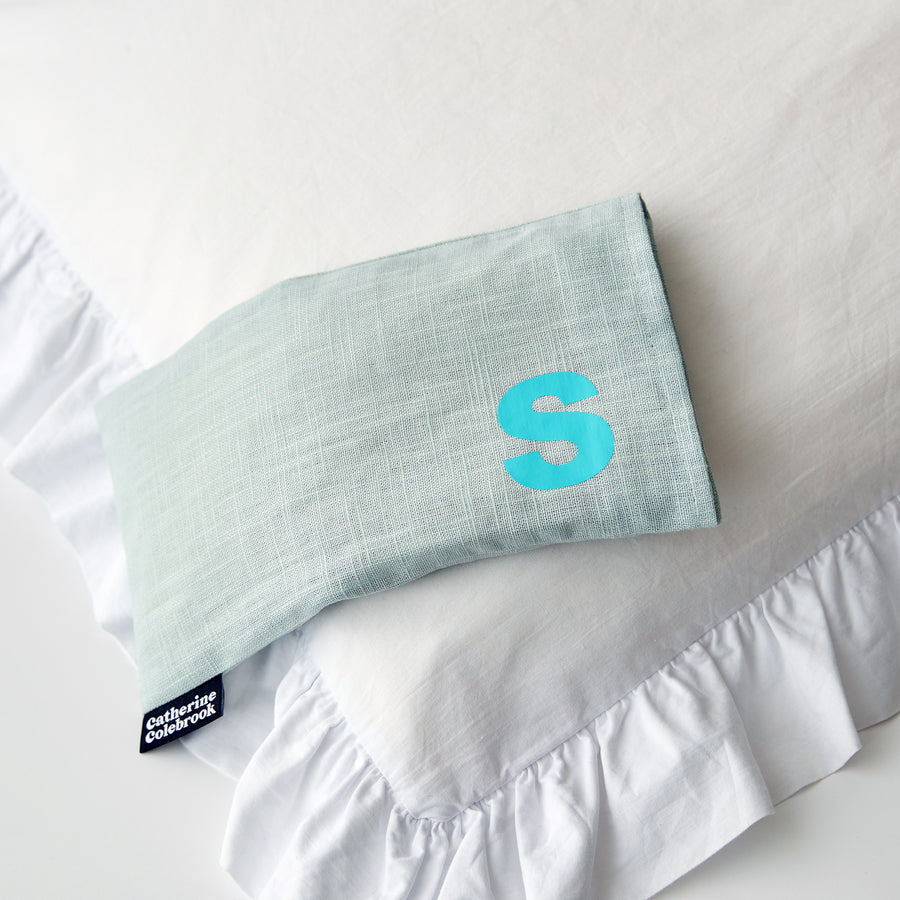 Catherine Colebrook mint linen eye pillow with turquoise initial on the bottom right with optional lavender