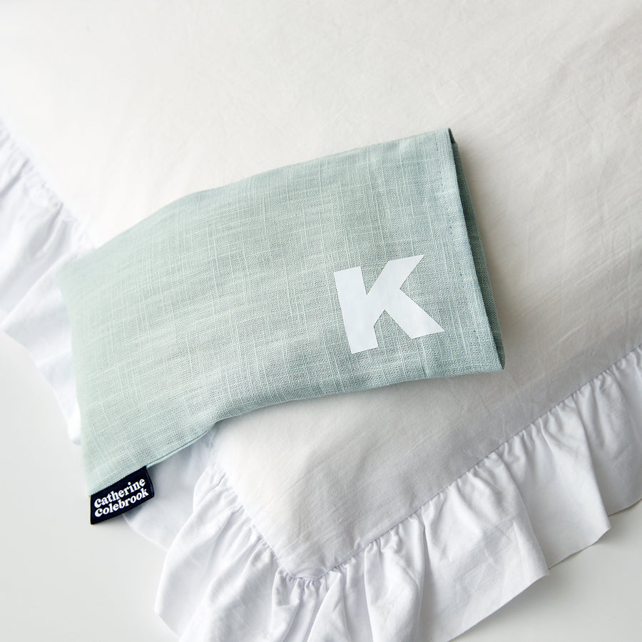 Catherine Colebrook mint linen eye pillow with white initial on the bottom right with optional lavender