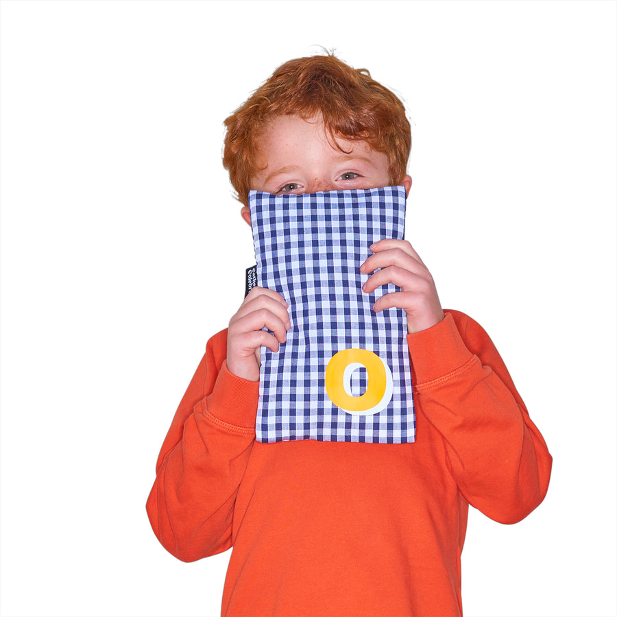 Catherine Colebrook cute navy gingham hot water bottle with ‘3D’ style initial in bottom right corner in yellow with white highlights being held by young boy