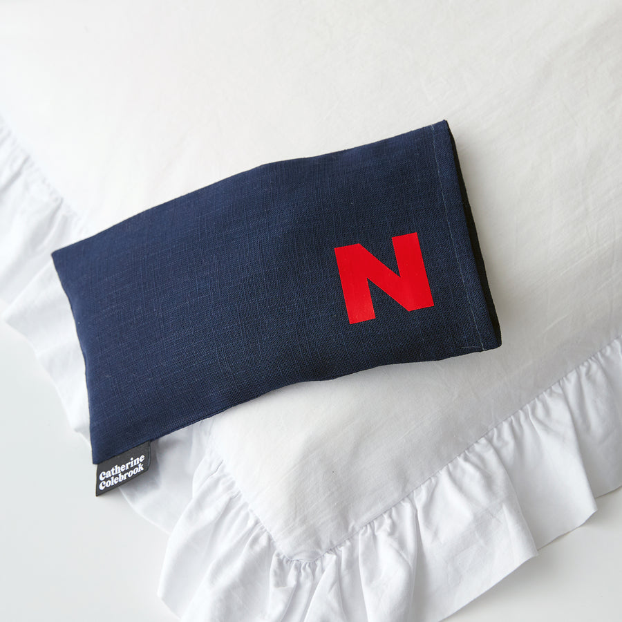 Catherine Colebrook navy linen eye pillow with red initial on the bottom right with optional lavender
