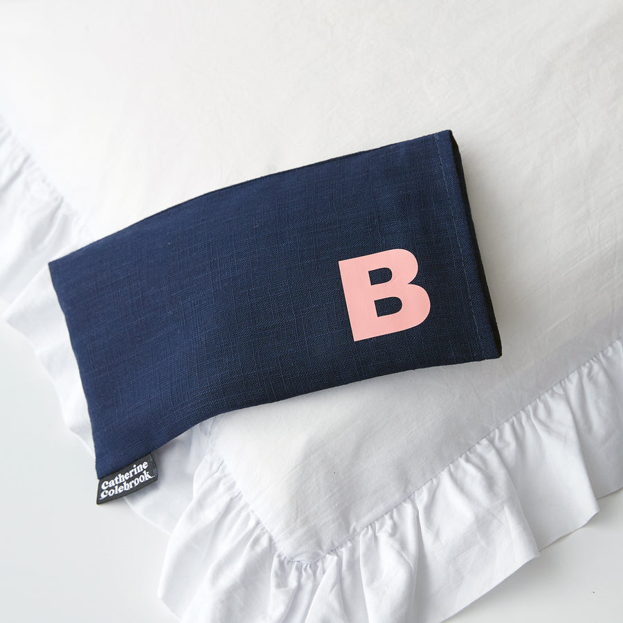 Catherine Colebrook navy linen eye pillow with salmon pink initial on the bottom right with optional lavender