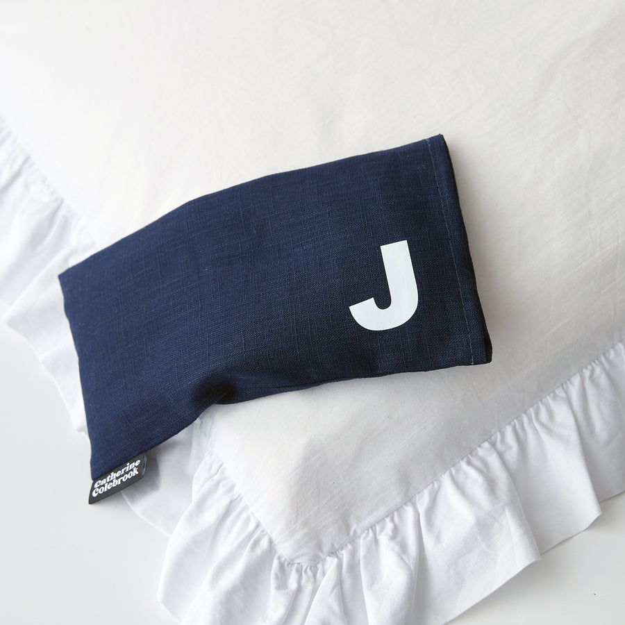 Catherine Colebrook navy linen eye pillow with white initial on the bottom right with optional lavender