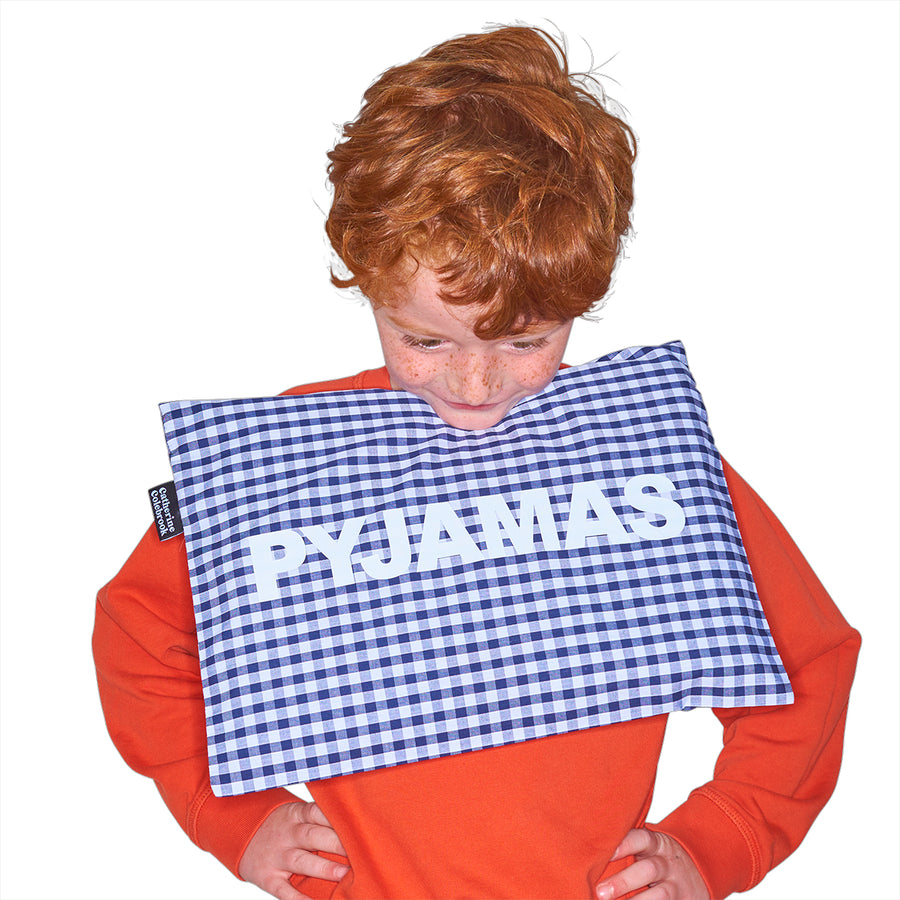 Catherine Colebrook navy gingham pyjama case with bold white ‘pyjamas' text on the front being held by young boy